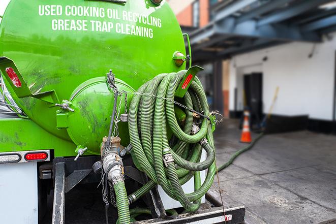 a grease trap pumping service in action at a commercial building in Capistrano Beach, CA